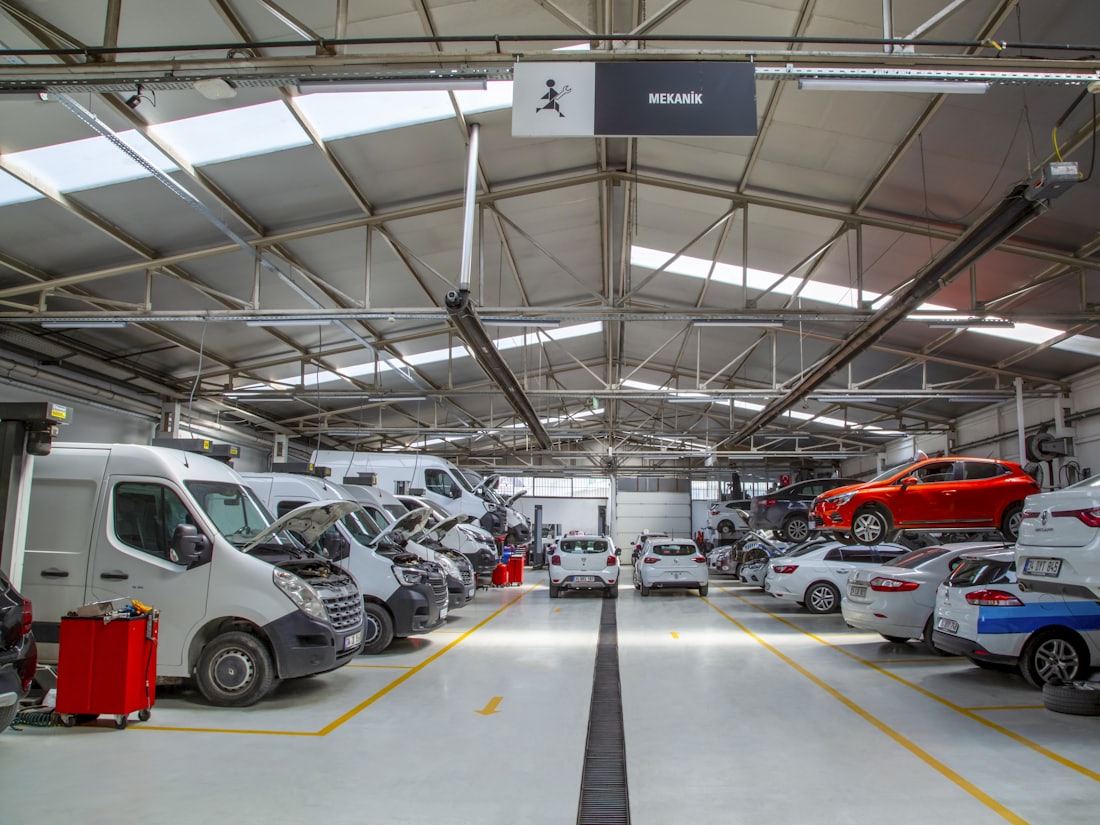 Interior of a vehicle workshop with vans and cars being worked on
