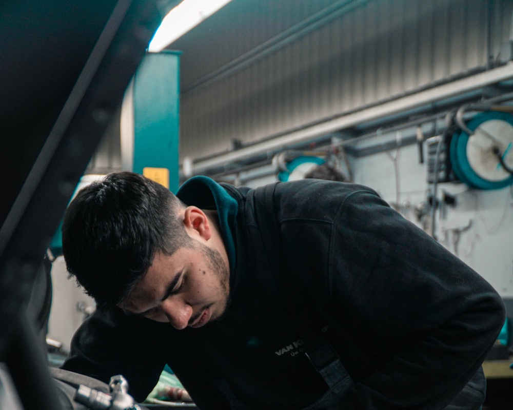 A mechanic concentrating while working on a car in the workshop