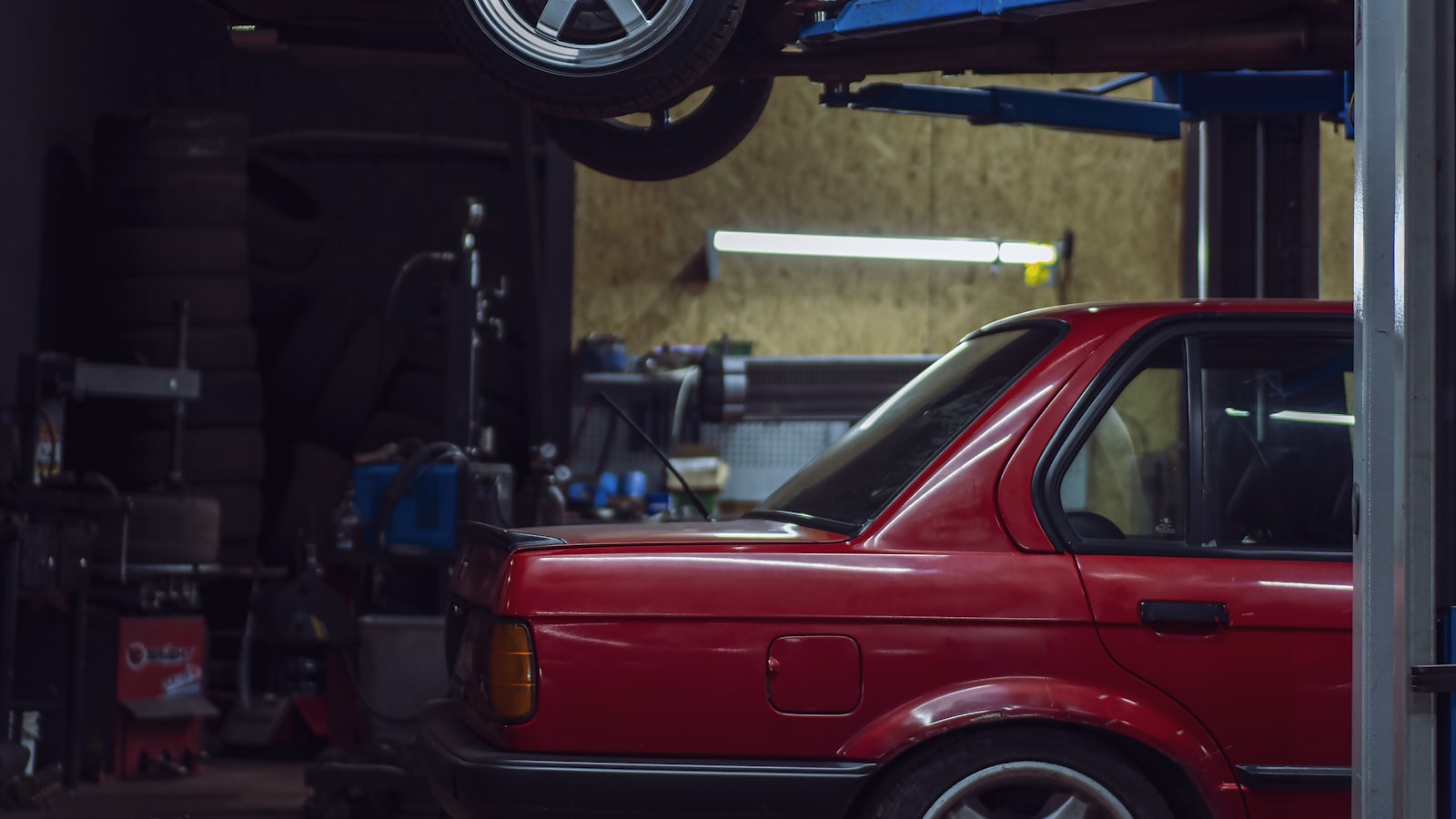 A car raised on a two-post ramp ready for an MOT inspection
