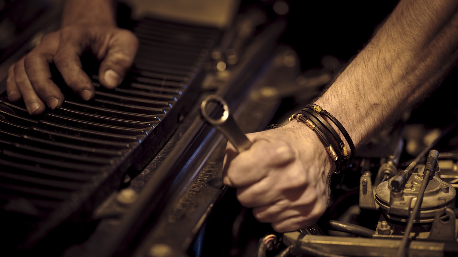 A mechanic using a spanner to repair a car engine